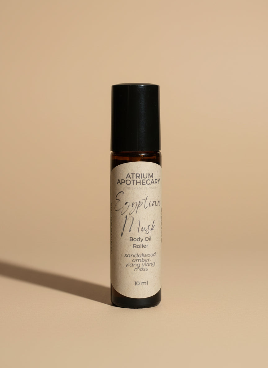 Atrium Apothecary Egyptian Musk Body Oil Roller on a white surface with a blurred background
