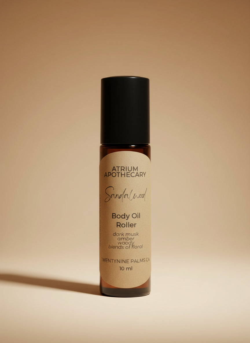 Body oil roller bottle with 'Atrium Apothecary' branding on a white surface.
