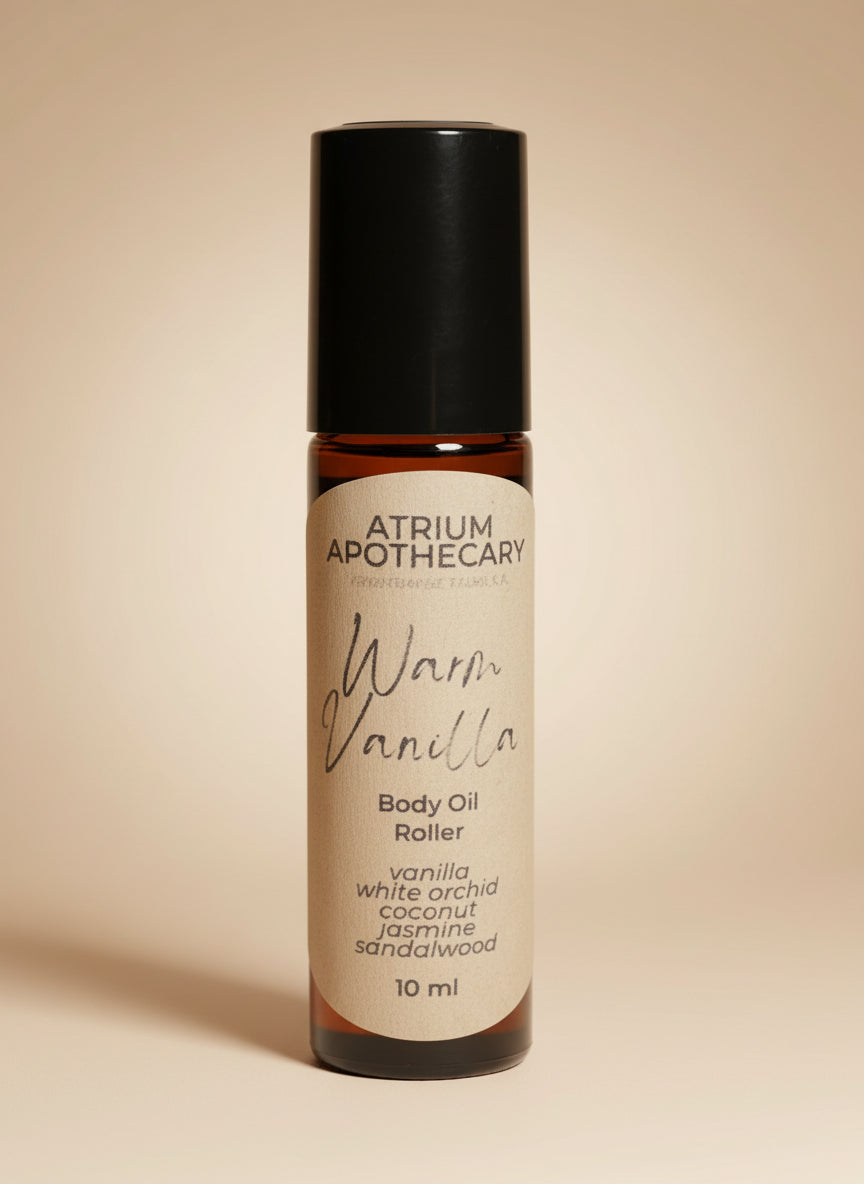 Body oil roller with 'Atrium Apothecary' branding on a dark background