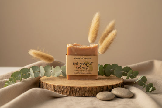 Bar of soap with grapefruit slices and leaves on a light background